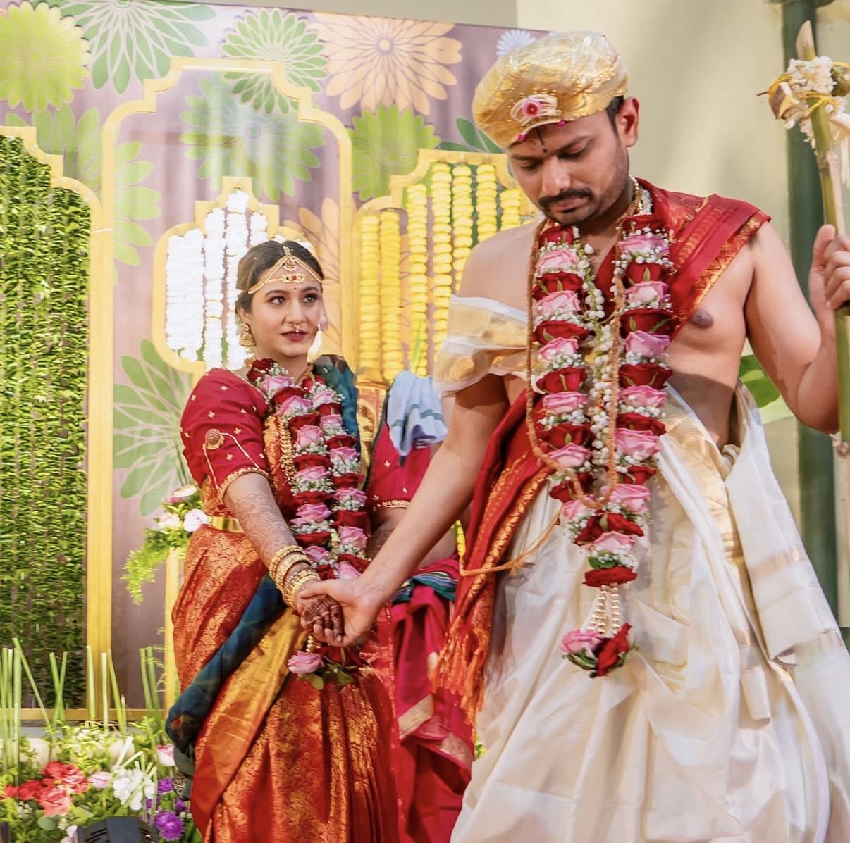 A South Indian couple at the mandap, garlands on, hands joined