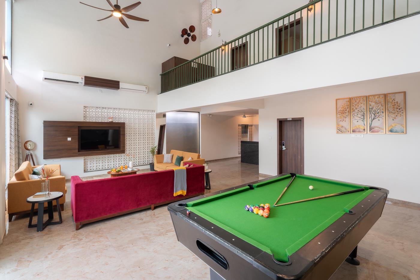 A pool table in the villa lounge with the mezzanine railing above