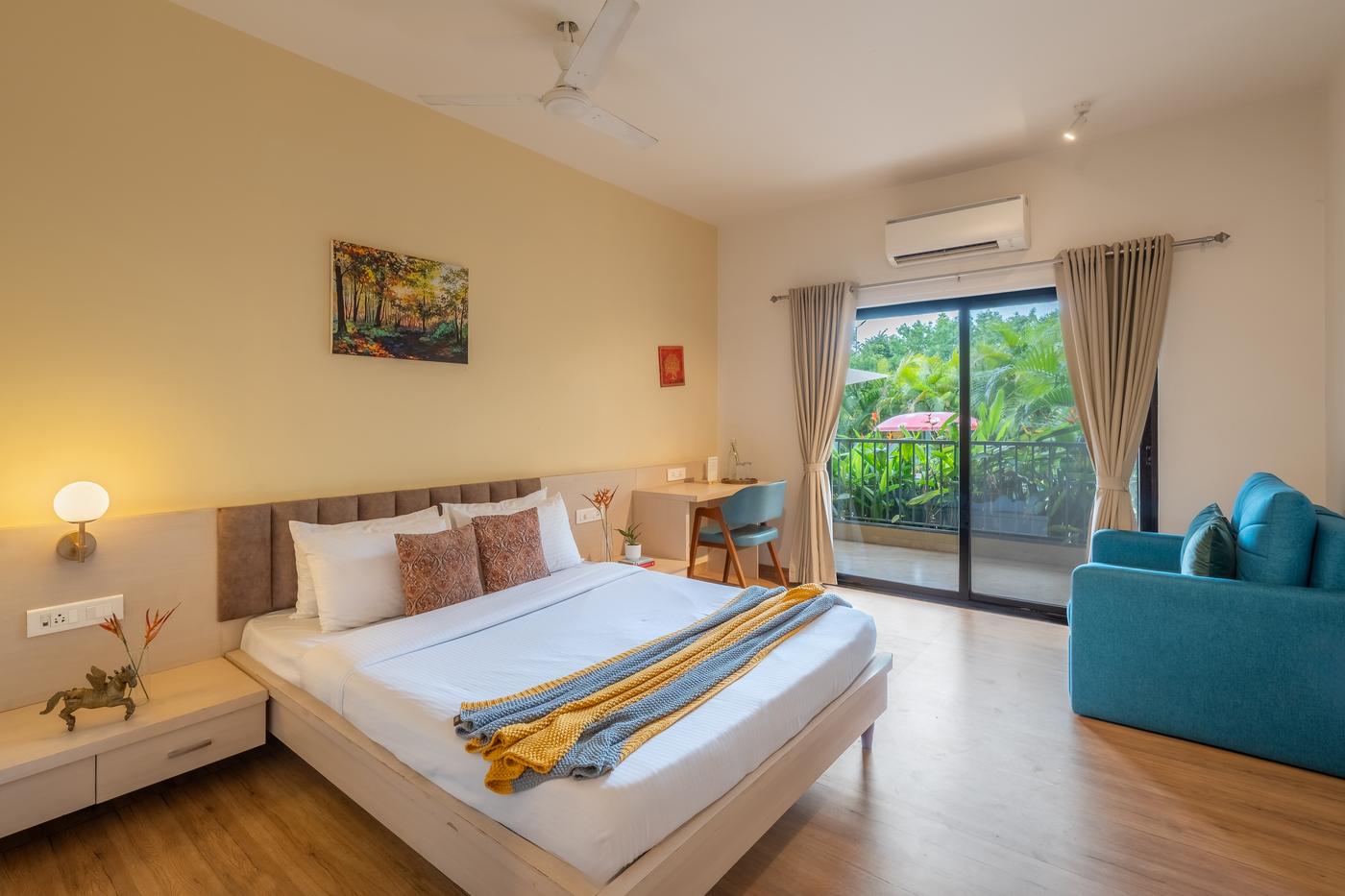 A guest room at Atithi Nivas with a balcony opening onto the gardens
