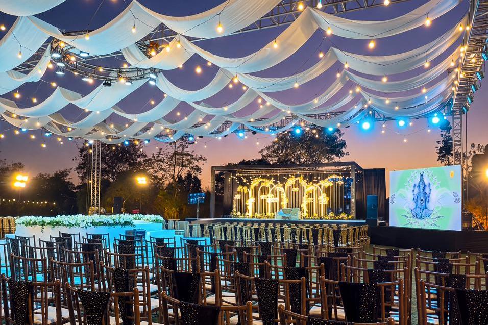 Vishal-Van lawn at dusk under a canopy of draped fabric and lights, set for a reception